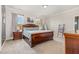 This bedroom features a wooden bed frame, soft, neutral carpet, and is brightened with natural light from two windows at 664 Old Dairy Dr, Wake Forest, NC 27587