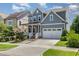 Beautiful exterior of a well-manicured home, showcasing a two-car garage and inviting front porch with colorful flowers at 664 Old Dairy Dr, Wake Forest, NC 27587
