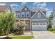 Charming two-story home with a welcoming front porch, attached two-car garage, and well-maintained landscaping at 664 Old Dairy Dr, Wake Forest, NC 27587