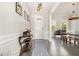 Bright foyer featuring dark hardwood floors, elegant wainscoting, stylish light fixtures, and an open view to dining at 664 Old Dairy Dr, Wake Forest, NC 27587