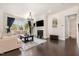 Cozy living room featuring a fireplace with shiplap detail, dark hardwood floors, and ample natural light at 664 Old Dairy Dr, Wake Forest, NC 27587