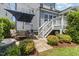 Charming backyard patio with outdoor seating, an umbrella, stairs to the deck, and lush landscaping at 664 Old Dairy Dr, Wake Forest, NC 27587