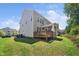 Backyard showcasing a well-maintained lawn, deck, and screened porch, ideal for outdoor living and entertaining at 7301 Villoria Ln, Raleigh, NC 27617