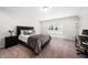 Comfortable bedroom boasts neutral tones, plush carpeting, and a relaxing atmosphere, complemented by natural light at 7301 Villoria Ln, Raleigh, NC 27617