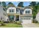 Charming two-story home with a well-manicured lawn, attached garage, and craftsman-style architectural details at 7301 Villoria Ln, Raleigh, NC 27617