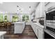Modern kitchen with white cabinets, stainless steel appliances, and an open layout with an eat-in dining area at 7301 Villoria Ln, Raleigh, NC 27617