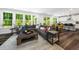 Open-concept living room with a modern sectional sofa, hardwood floors, and seamless access to the kitchen at 7301 Villoria Ln, Raleigh, NC 27617