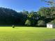 Lush green backyard with mature trees and a storage shed, providing ample space and tranquility at 759 Wheeler Dr, Angier, NC 27501