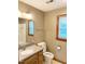 Bathroom featuring a single sink vanity, toilet, large mirror, and a window at 759 Wheeler Dr, Angier, NC 27501