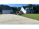 Charming two-story home with a well-manicured lawn and a large driveway leading to an attached garage at 759 Wheeler Dr, Angier, NC 27501