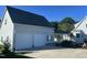 Exterior view of a two-car garage with white doors, attached to a house via a covered walkway at 759 Wheeler Dr, Angier, NC 27501