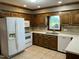 Kitchen with white appliances, wooden cabinetry, and tile flooring at 759 Wheeler Dr, Angier, NC 27501