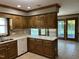 Open kitchen with wooden cabinetry, a white countertop, and access to an outdoor porch at 759 Wheeler Dr, Angier, NC 27501