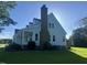 Rear view of home featuring a chimney, well-maintained lawn, and mature landscaping at 759 Wheeler Dr, Angier, NC 27501