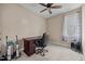 Neutral bedroom featuring a dark brown desk with black office chair and light-filled window at 80 Scarlet Bell Dr, Youngsville, NC 27596