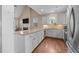Beautiful kitchen featuring granite countertops, white cabinetry, stainless steel appliances, and hardwood floors at 80 Scarlet Bell Dr, Youngsville, NC 27596