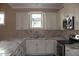 Close-up view of the kitchen, highlighting the white cabinetry, granite countertops, and stainless steel appliances at 80 Scarlet Bell Dr, Youngsville, NC 27596