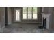 View of the living room showing a fireplace, large windows, and a door to a patio at 80 Scarlet Bell Dr, Youngsville, NC 27596