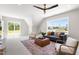 Sun-filled living area featuring a comfortable sofa, stylish decor, and large windows with neighborhood views at 808 Shiloh Hills Dr, Fuquay Varina, NC 27526