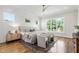 This main bedroom boasts hardwood floors, white paneled walls, a ceiling fan, and many bright windows at 808 Shiloh Hills Dr, Fuquay Varina, NC 27526