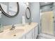 Bathroom with dual vanity sinks, chrome fixtures, oval mirrors, and walk-in shower at 8513 Buscot Ct, Raleigh, NC 27615