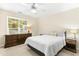 A calm bedroom with a ceiling fan, a large window, and neutral colored walls at 8513 Buscot Ct, Raleigh, NC 27615