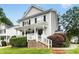 Charming two-story home with white siding, black shutters, front porch, and landscaped yard at 8513 Buscot Ct, Raleigh, NC 27615