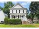 Charming two-story home with white siding, black shutters, front porch, and landscaped yard at 8513 Buscot Ct, Raleigh, NC 27615