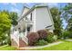 Charming two-story home featuring a welcoming front porch with white railings and blooming hanging baskets, surrounded by greenery at 8513 Buscot Ct, Raleigh, NC 27615