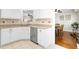 Bright kitchen featuring stainless steel dishwasher, white cabinets and a view into the dining room at 8513 Buscot Ct, Raleigh, NC 27615