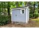Storage shed has a grey exterior and is surrounded by trees and greenery at 8513 Buscot Ct, Raleigh, NC 27615