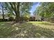 Expansive backyard with mature trees, a brick home exterior, and a wooden fence for privacy at 905 Aversboro Rd, Garner, NC 27529