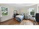 Cozy bedroom with hardwood floors, two large windows, and traditional furnishings at 905 Aversboro Rd, Garner, NC 27529