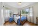 Bright bedroom featuring a four-poster bed, hardwood floors, and two windows with sheer curtains at 905 Aversboro Rd, Garner, NC 27529
