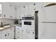 This kitchen features white cabinetry, vintage appliances and ample counter space at 905 Aversboro Rd, Garner, NC 27529