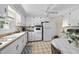 Traditional white kitchen with updated appliances, checkerboard flooring, ceiling fan, and cozy dining area at 905 Aversboro Rd, Garner, NC 27529
