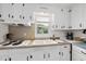 Bright kitchen sink features a double basin, window view, and essential appliances on a white countertop at 905 Aversboro Rd, Garner, NC 27529