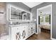 Bright bathroom featuring double sink vanity, backlit mirror, and adjoining bedroom at 10 Wilders Ln, Louisburg, NC 27549
