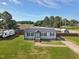 Charming gray home features a well-manicured lawn and a striking blue front door, exuding curb appeal at 10 Wilders Ln, Louisburg, NC 27549