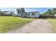 Home exterior featuring a large yard, gravel driveway, and quaint front porch at 10 Wilders Ln, Louisburg, NC 27549