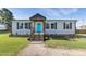 Charming home featuring a turquoise front door, dark shutters, and a well-manicured lawn at 10 Wilders Ln, Louisburg, NC 27549