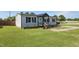 Inviting home features a cozy porch with an American flag, a well-maintained lawn and fresh landscaping at 10 Wilders Ln, Louisburg, NC 27549
