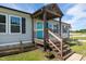 Inviting front porch with wood stairs, a turquoise door, and landscaped flower bed at 10 Wilders Ln, Louisburg, NC 27549