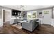 Bright living room featuring a gray sofa, a large TV, and ample natural light at 10 Wilders Ln, Louisburg, NC 27549