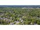 An aerial view shows a neighborhood with abundant mature trees, well-kept homes, and tree-lined streets at 1007 W Markham Ave, Durham, NC 27701