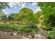 Scenic backyard featuring a small wooden bridge, lush greenery, and rock lined stream at 1007 W Markham Ave, Durham, NC 27701