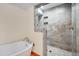 Bright bathroom featuring a tub and a walk-in shower with stone tiles at 1007 W Markham Ave, Durham, NC 27701