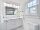 Bright bathroom with double vanity, ample lighting, and black and white mosaic tile floor at 1007 W Markham Ave, Durham, NC 27701