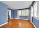 Spacious bedroom with hardwood flooring, blue walls, and natural light from several windows at 1007 W Markham Ave, Durham, NC 27701