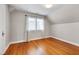 Cozy bedroom features a large window with hardwood floors and light gray walls at 1007 W Markham Ave, Durham, NC 27701
